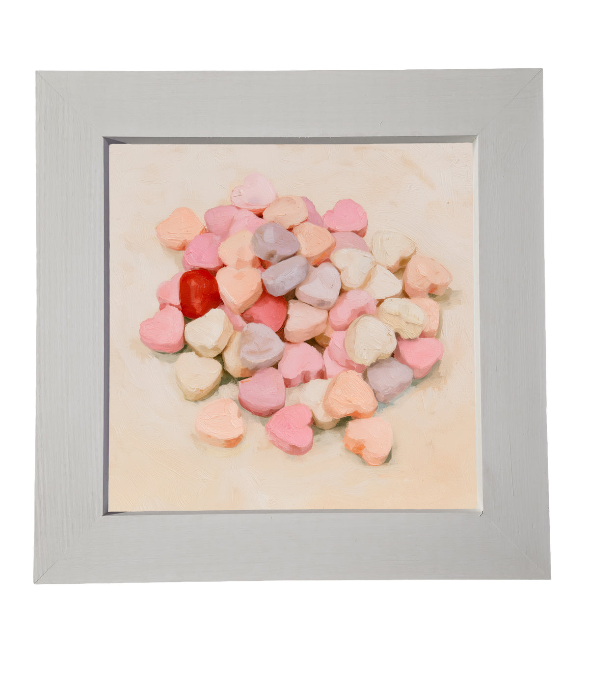 Old-fashioned pastel conversation hearts arranged in a rustic framed artwork