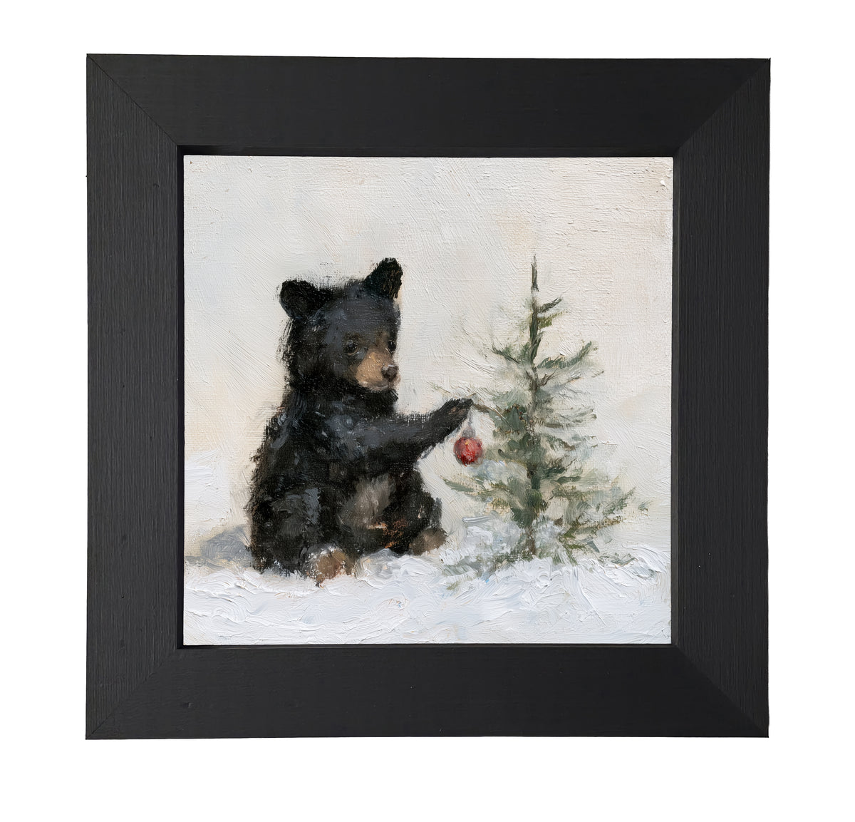 young black bear sitting in a rustic winter landscape, framed for Christmas decor